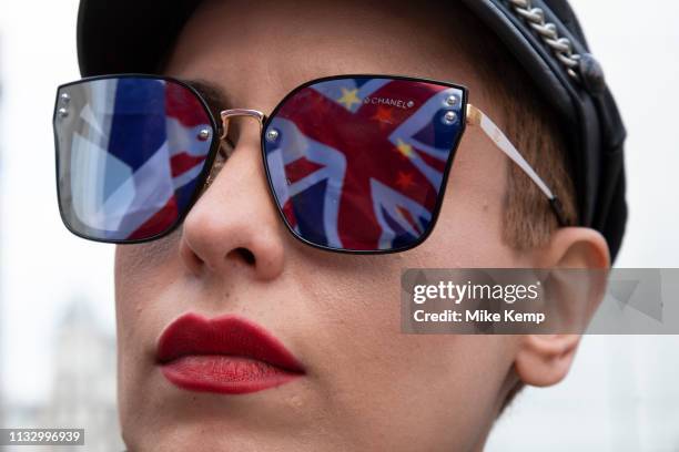 Anti Brexit pro Europe demonstrator has the Union Jack flag reflected in her sunglasses in Westminster on 26th March 2019 in London, England, United...