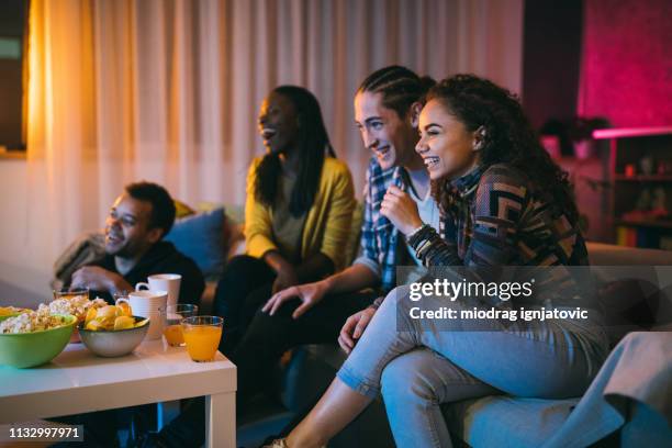 friends watching comedy movie at home - watching television stock pictures, royalty-free photos & images