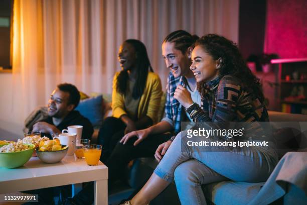 friends watching comedy movie at home - young couple at movie together imagens e fotografias de stock