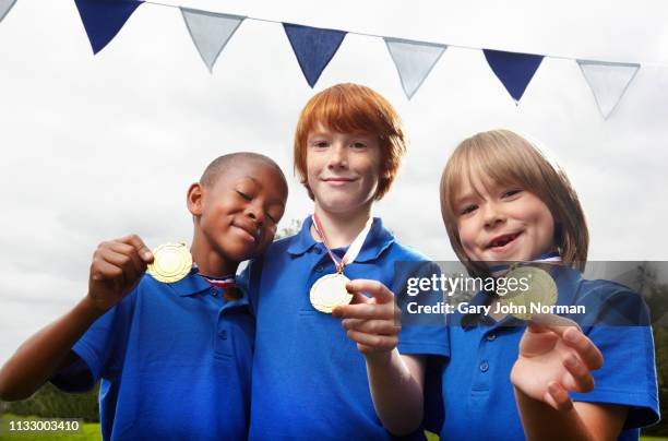 school boys holding medals for sporting achievement - champions day three stock pictures, royalty-free photos & images