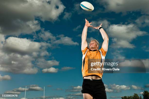 rugby player leaping up to catch ball - super rugby stock-fotos und bilder