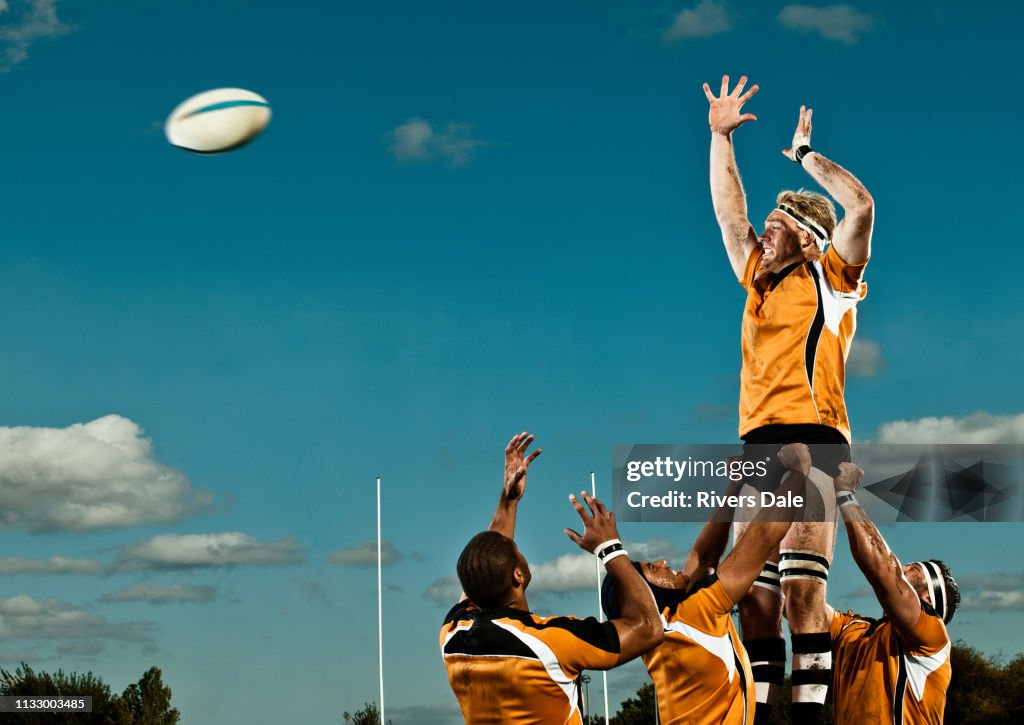 Rugby player leaping up to catch ball