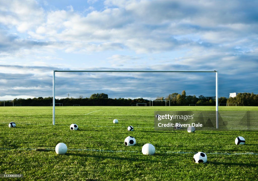 Footballs on empty pitch