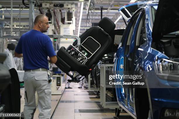 Workers assemble cars on the assembly line for Volkswagen Touareg, Touran and T-Roc models at the Volkswagen factory on March 01, 2019 in Wolfsburg,...