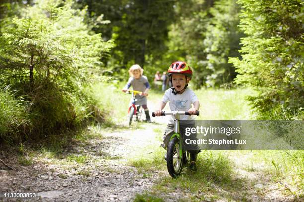 toddler boy riding bike on dirt path - junge fahrrad stock-fotos und bilder