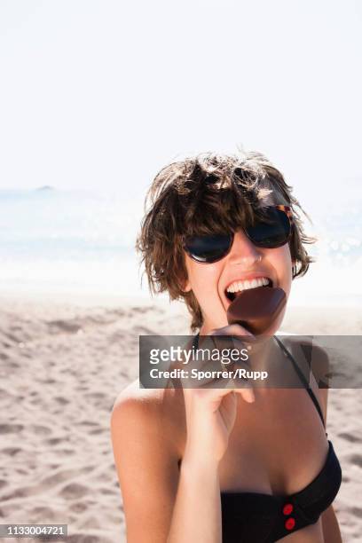woman eating ice cream on beach - woman ice cream stock pictures, royalty-free photos & images