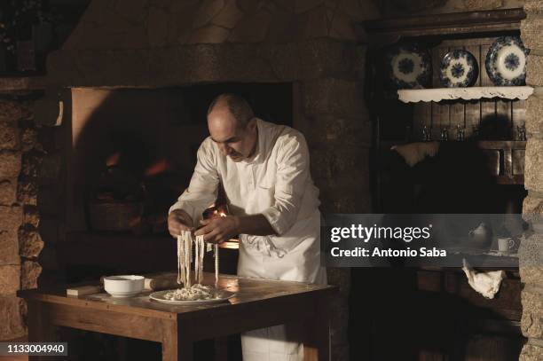 cook handling pasta dough in kitchen - cooking pasta stock pictures, royalty-free photos & images