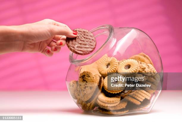 woman stealing biscuit, caught in the act. - temptation stock-fotos und bilder