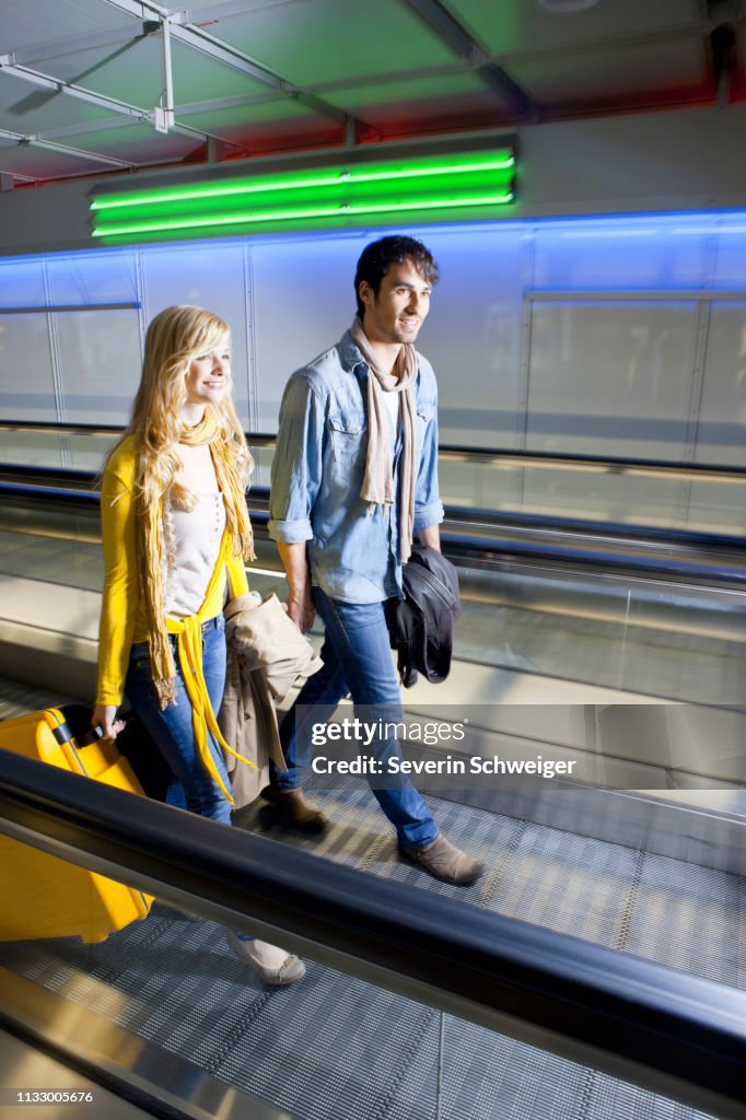 Couple on moving walkway in airport