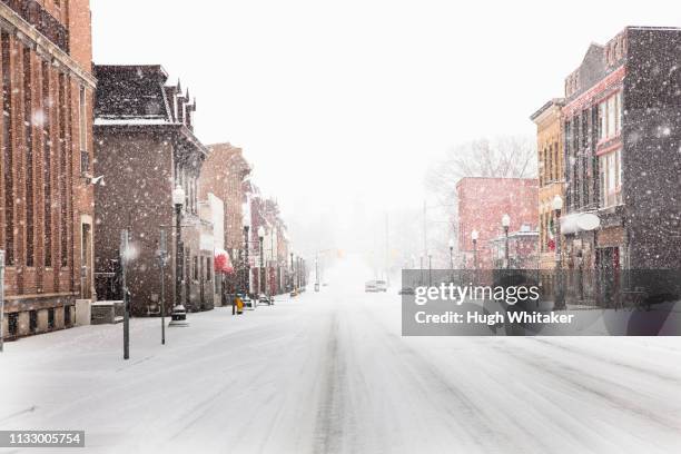 snow falling on city street - winter town stock pictures, royalty-free photos & images