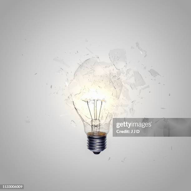 close up of light bulb shattering - exploding lightbulb stock pictures, royalty-free photos & images