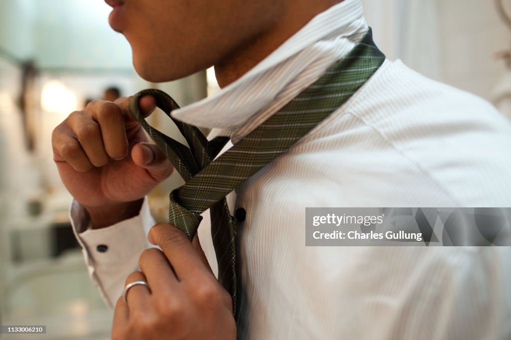 Man putting on tie