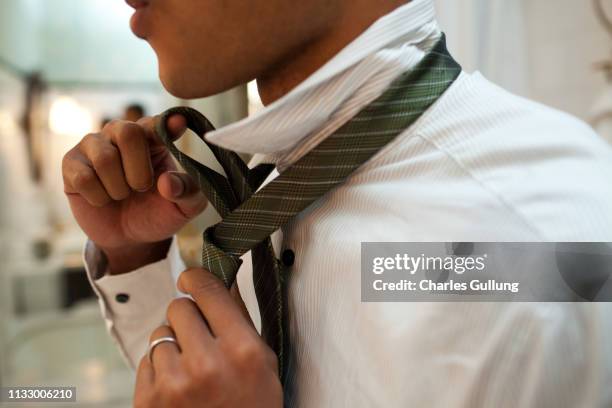 man putting on tie - ties foto e immagini stock