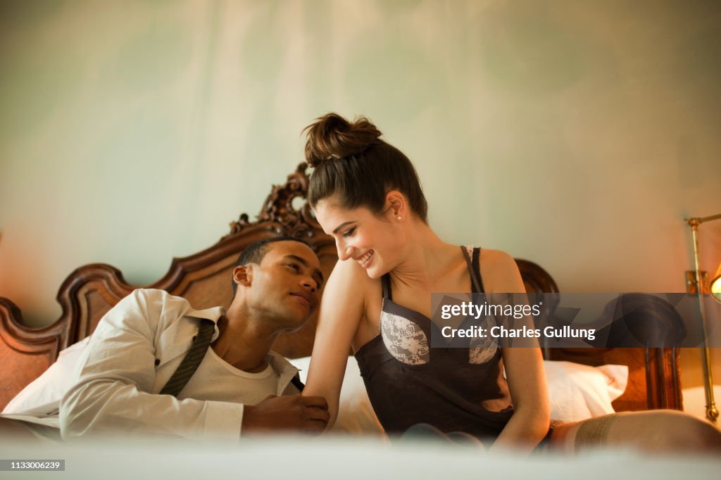Couple sitting on double bed