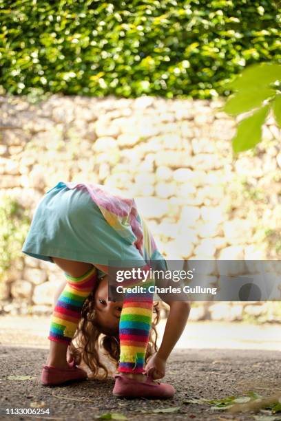 young girl peeking between legs - bending over in skirt stock-fotos und bilder