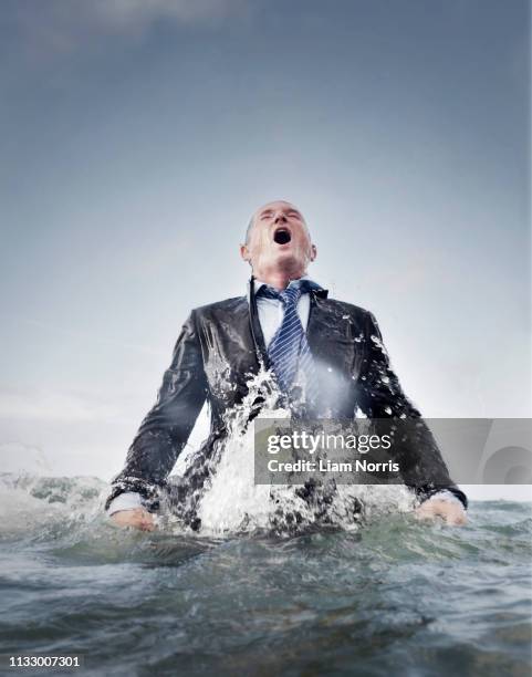 a businessman coming out of the sea - man splashed with colour fotografías e imágenes de stock