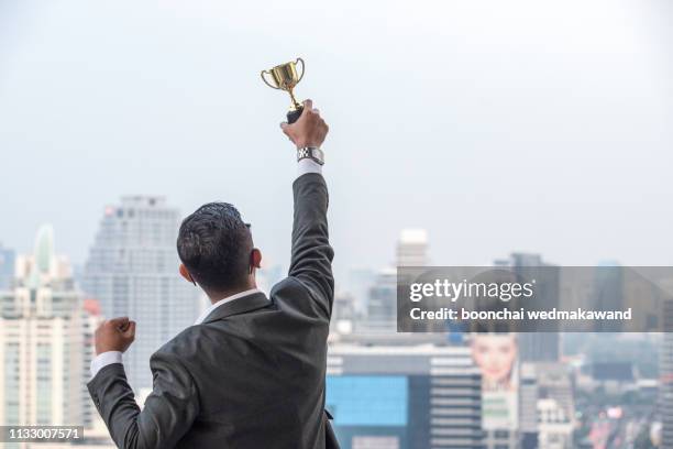 businessman celebrating with trophy - asian championship bildbanksfoton och bilder