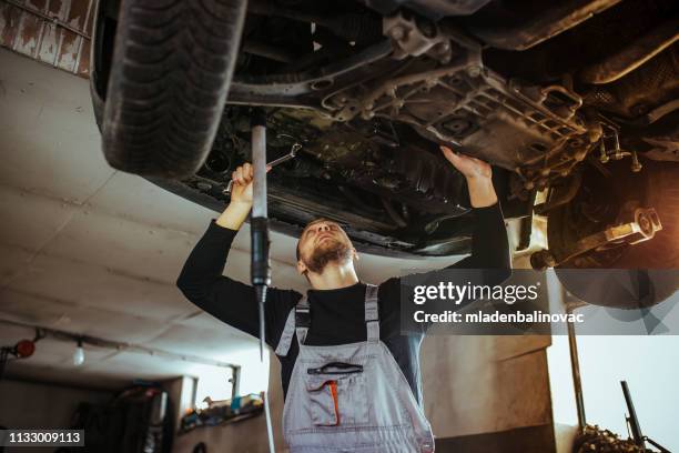 kfz-mechaniker in garage - hochziehen stock-fotos und bilder