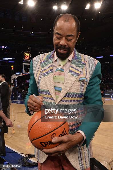 Retired NBA Player Walt Frazier signs a basketball before the game ...