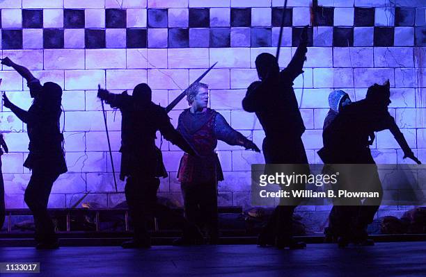 Members of the Commonwealth Shakespeare Company rehearse a scene under blue stage lights from Shakespeare's Henry V July 18, 2002 in Boston,...