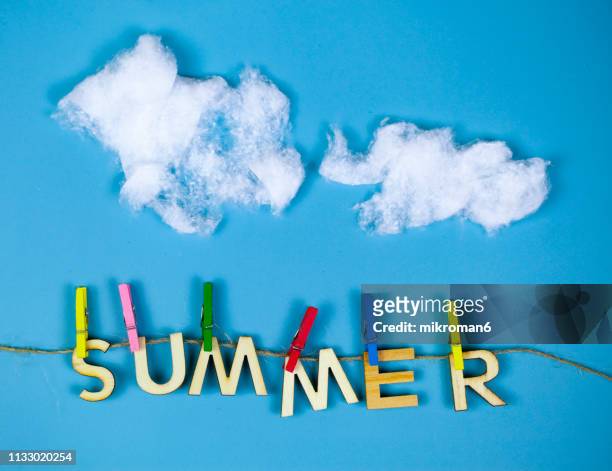 colorful wooden clothespins, clothes pegs with wooden letters saying summer - wattebausch stock-fotos und bilder