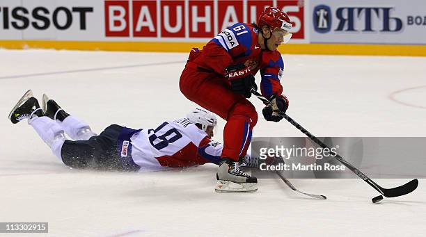Maxim Afinogenov of Russia and Gregory Kuznik of Slovenia battle for the puck during the IIHF World Championship group A match between Russia and...