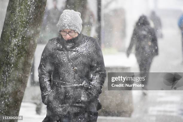 People are seen walking through a hail storm in Warsaw, Poland on March 26, 2019. A sudden hail storm, strong winds and a drop in temperature occured...