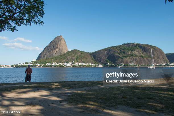fishing with sugar loaf - ponto de referência natural stock pictures, royalty-free photos & images