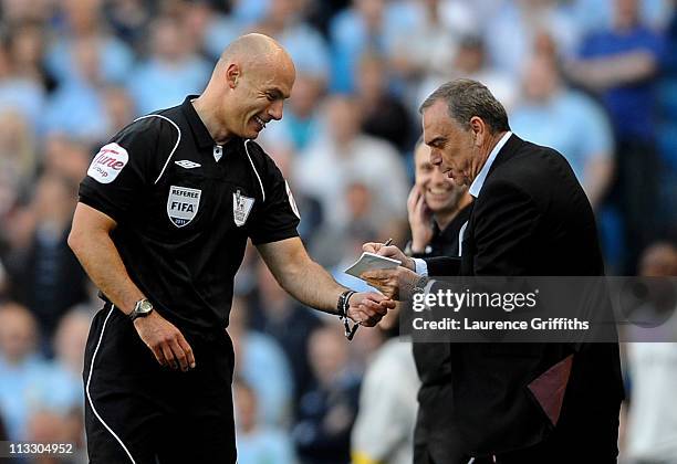 West Ham United Manager Avram Grant pretends to sign an autograph for Referee Howard Webb after he dropped his notebook during the Barclays Premier...