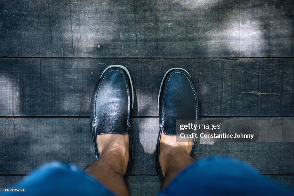 Low Section of Man Standing on Wooden Footpath View From Top