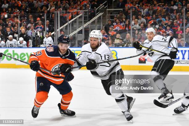 Edmonton Oilers right wing Josh Currie and Los Angeles Kings left wing Kyle Clifford skate to a loose puck on March 26, 2019 at Rogers Place in...