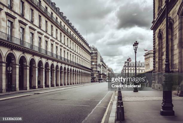 empty rue de rivoli street against dramatic sky in paris - continental stock-fotos und bilder