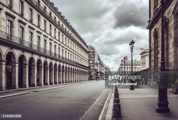 empty rue de rivoli street against dramatic sky in paris - de paris stock pictures, royalty-free photos & images