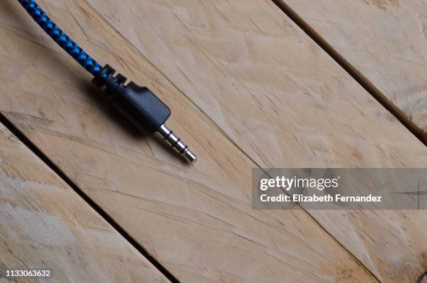 audio jack of headphones on wooden table - rca stock pictures, royalty-free photos & images