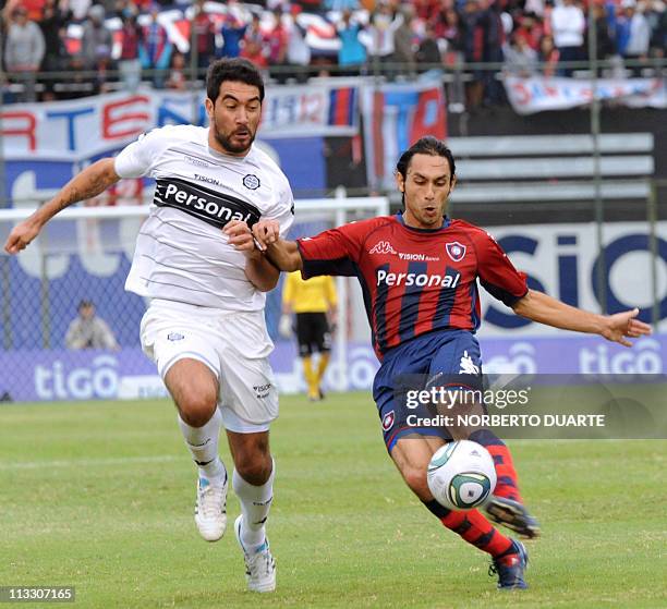 Olimpia's player Juan Carlos Ferreyra fights for the ball with Rodrigo Burgos of Cerro Porteno, during a Paraguayan tournament football match held in...