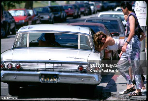 Girl talks to a man driving a classic car on Melrose Avenue August 8, 1993 West Hollywood , Los Angeles, California