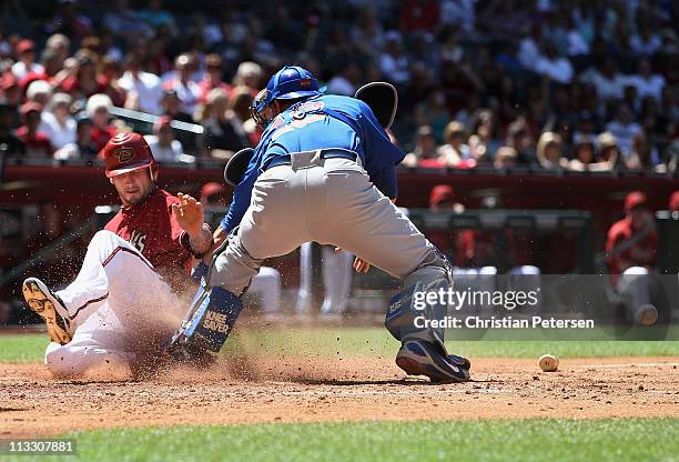 Ryan Roberts of the Arizona Diamondbacks safely slides in to score a run past the tag from catcher Geovany Soto of the Chicago Cubs during the fourth...