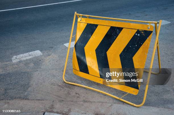 temporary folding metal chevron traffic management sign at a road intersection - detour stock-fotos und bilder