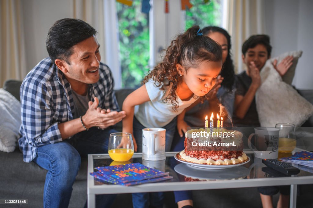 Girl celebrating birthday with family at home