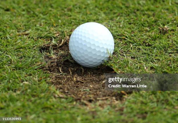 Richie Ramsay of Scotland find his ball in a divot on the 12th fairway during the resumption of the weather affected second round of the Oman Open at...
