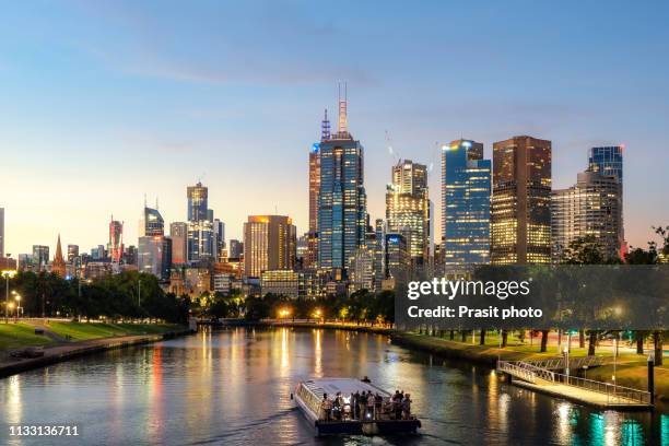 cruise ship with melbourne skyline and yarra river at night in melbourne, victoria, australia. - melbourne river cruise stock pictures, royalty-free photos & images