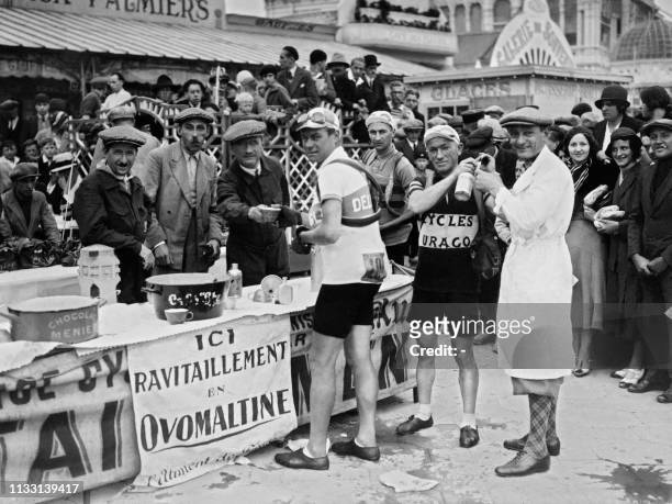 The cyclists are refueling during the 20th stage between Saint-Malo and Amiens of the Tour de France in July 1932.
