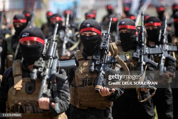 Fighters from the Kurdish Women's Protection units participate in a military parade on March 27 celebrating the total elimination of the Islamic...