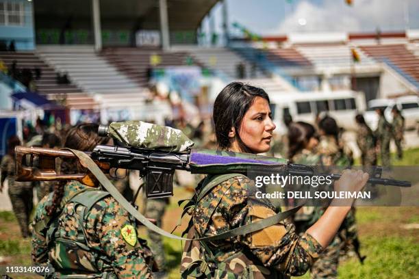 Fighters from the Kurdish Women's Protection units participate in a military parade on March 27 celebrating the total elimination of the Islamic...