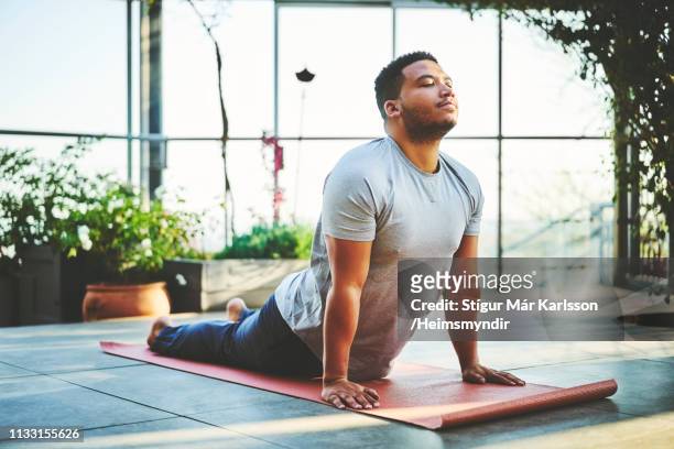 young man practicing upward facing dog pose - only men stock pictures, royalty-free photos & images