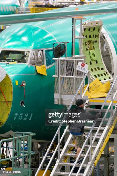 Boeing employeee climbs stairs up to a Boeing 737 MAX 8 in the company's factory on March 27, 2019 in Renton, Washington. In the wake of two 737 MAX...