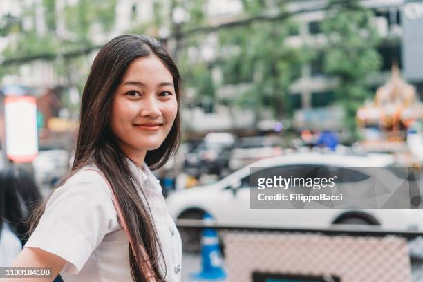 porträt einer jungen frau in der stadt. bangkok, thailand - thai ethnicity stock-fotos und bilder