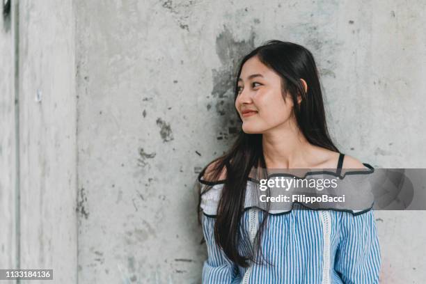 portrait of a young woman against a wall - thai culture stock pictures, royalty-free photos & images