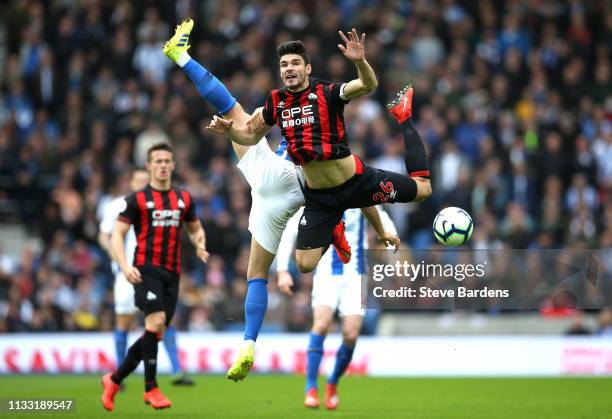 Christopher Schindler of Huddersfield Town collides with Alireza Jahanbakhsh of Brighton and Hove Albion during the Premier League match between...