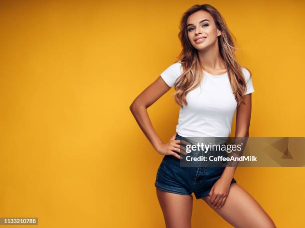 hermosa chica tiene una figura hermosa - denim shorts fotografías e imágenes de stock